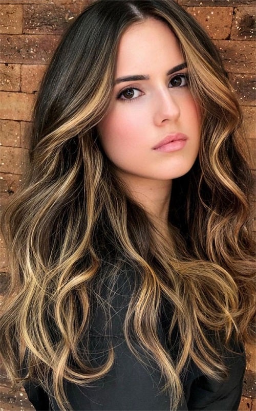 Honey blonde highlights brighten up your face and look perfect with beachy waves or soft, loose curls.